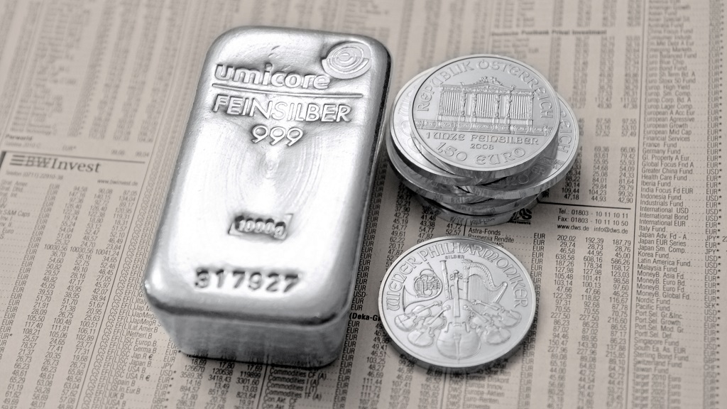 A 1-kilo silver bar and a Vienna Philharmonic coin appearing on the economic section of a newspaper